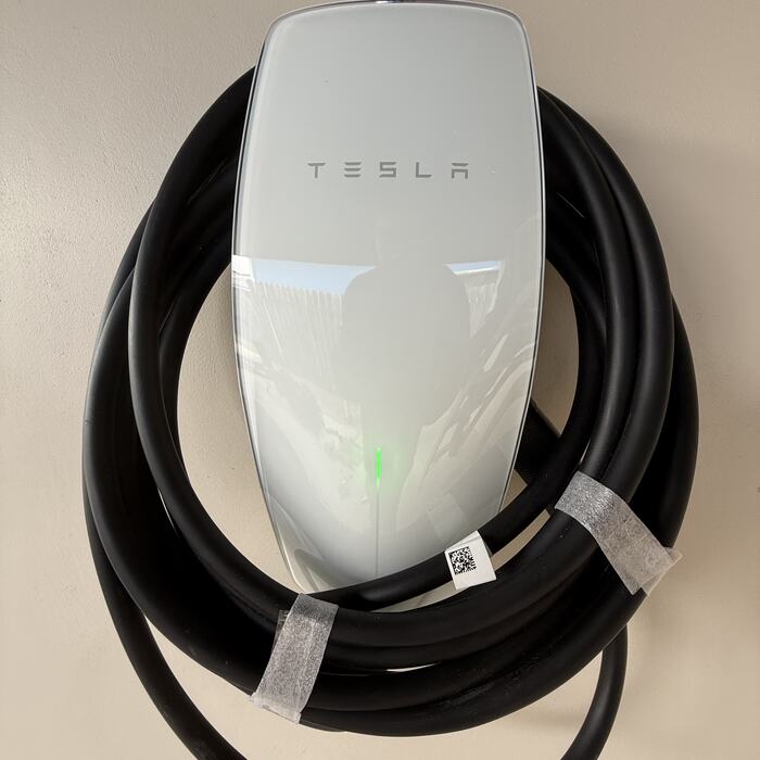 Tesla wall connector EV charger mounted on a garage wall
